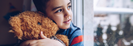 child hugging teddy bear